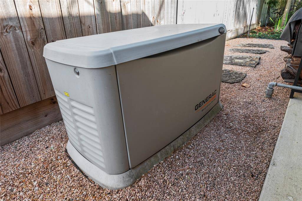 Close-up of the Generac Guardian Series generator—peace of mind for any power outage, discreetly placed behind outdoor kitchen pavillion