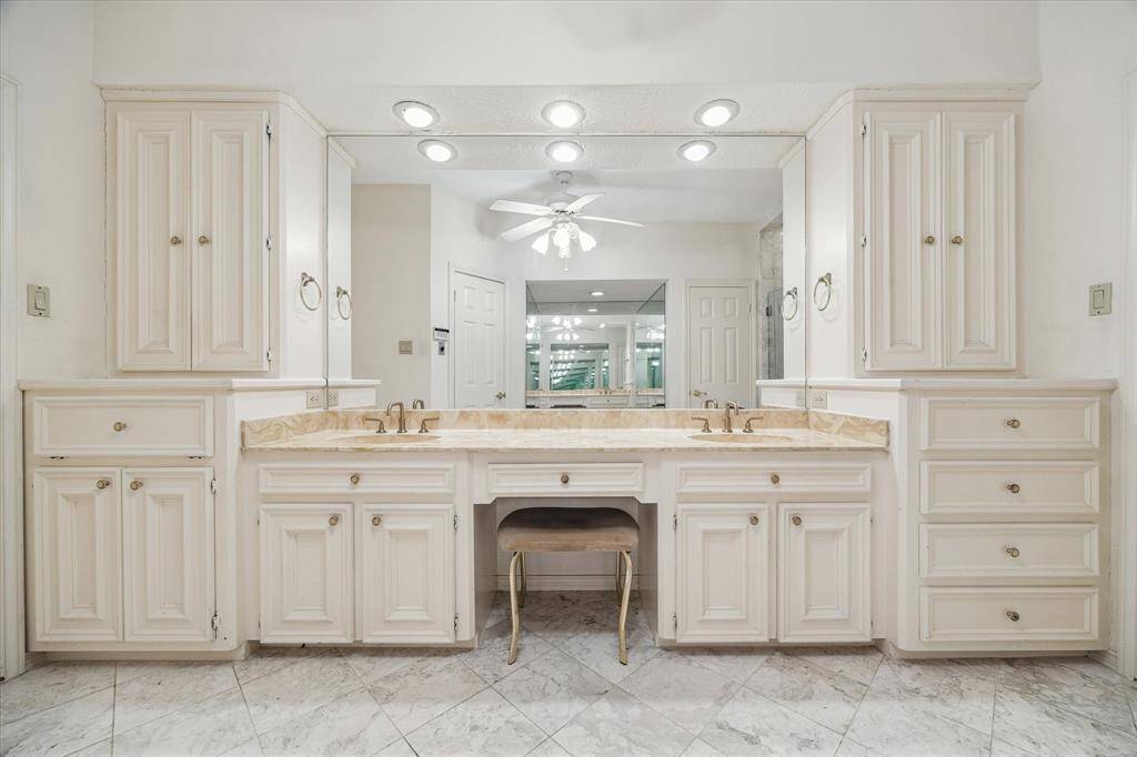 Another view of the master bathroom with double sinks, knee space, abundance of storage space and built in hamper.