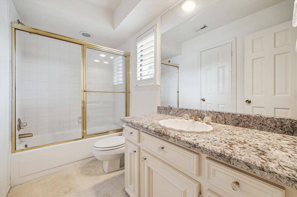 Second floor bathroom with spacious vanity and tub/shower combo with sliding shower door.