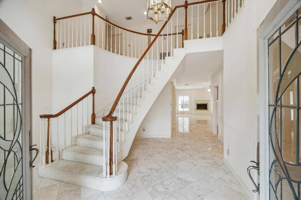 Two story entry with dramatic staircase