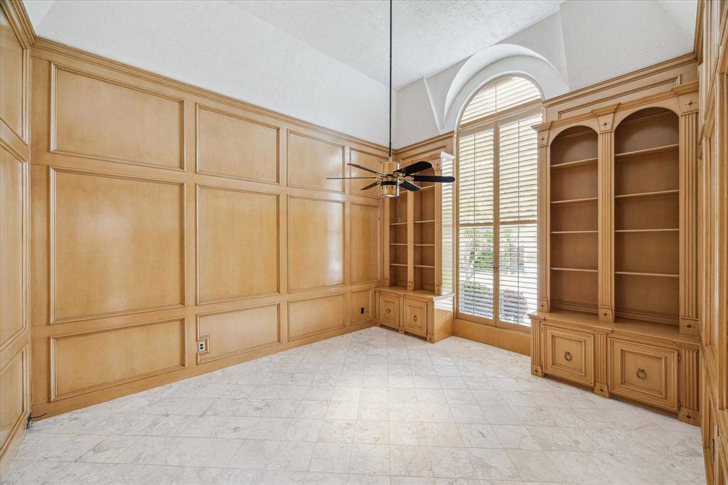 Formal study with paneled walls, high vaulted ceiling and marble floors.