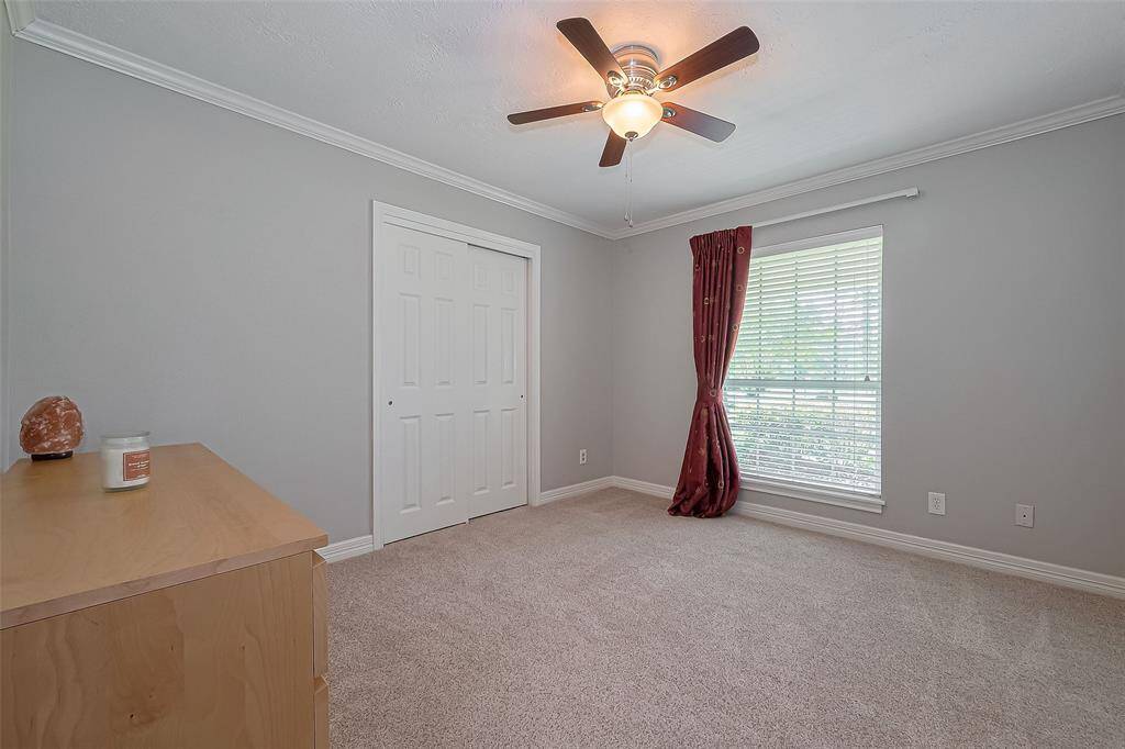 Third bedroom features a large closet, ceiling fan and plush carpet