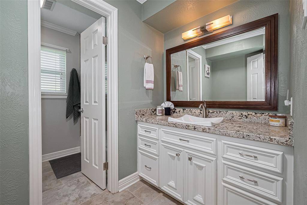 Second bathroom features granite counters, ample cabinet storage and a beautiful color palette.