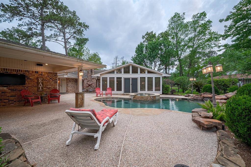 Outdoor kitchen features dual ceiling fans, stainless appliances and a half bath