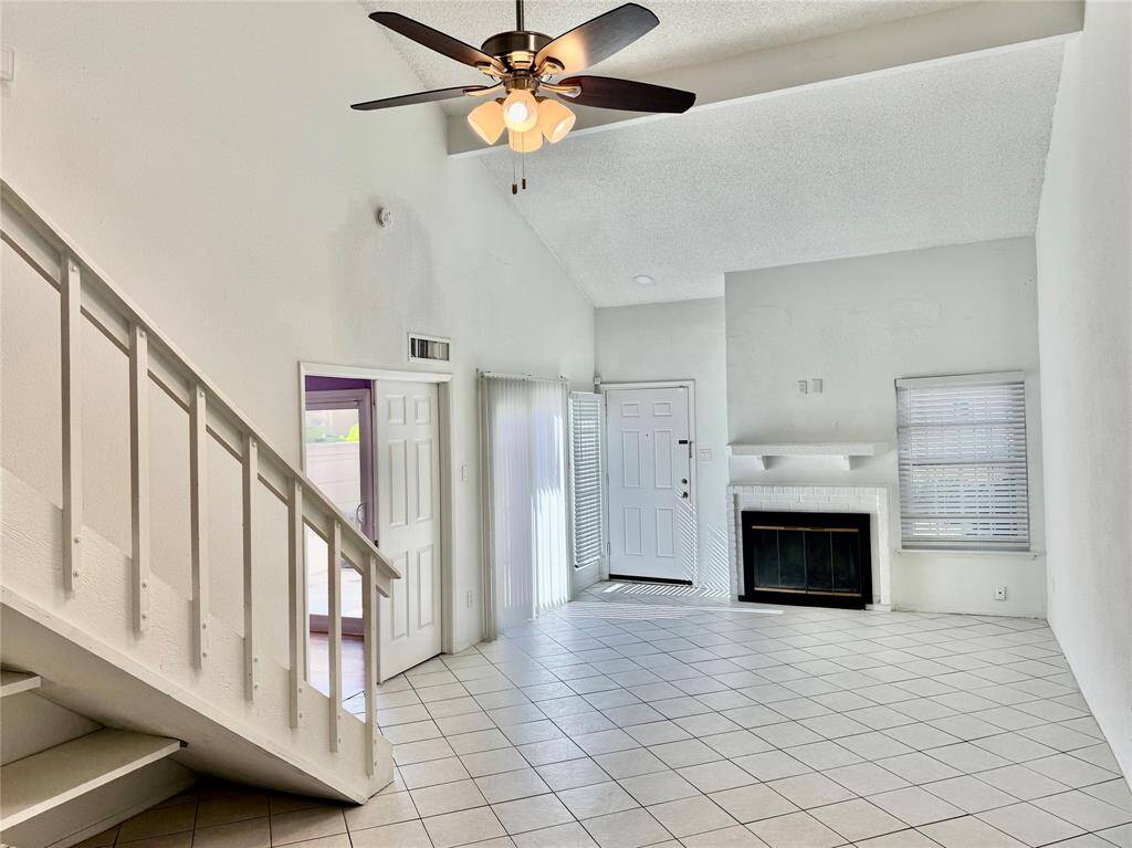 Another view of living room looking toward front door. Note the fireplace!