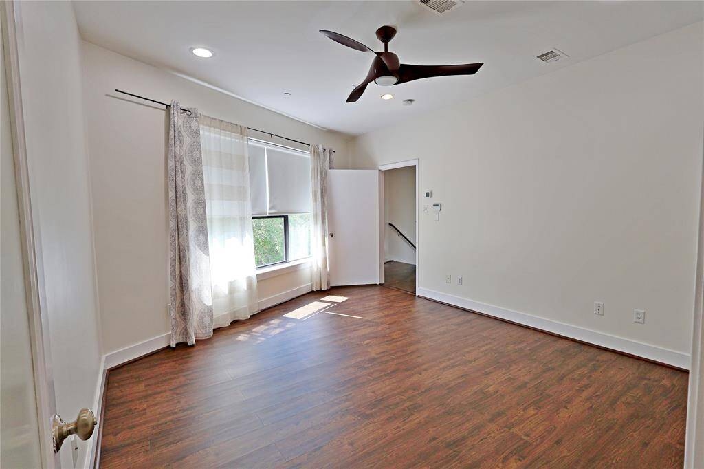 Another view of Primary bedroom with luxury window coverings and electric blinds with remote