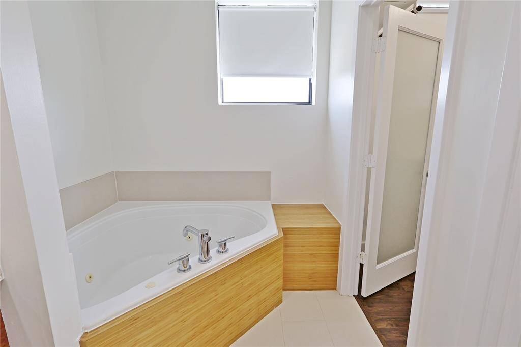 Jetted soaking tub located in primary bedroom