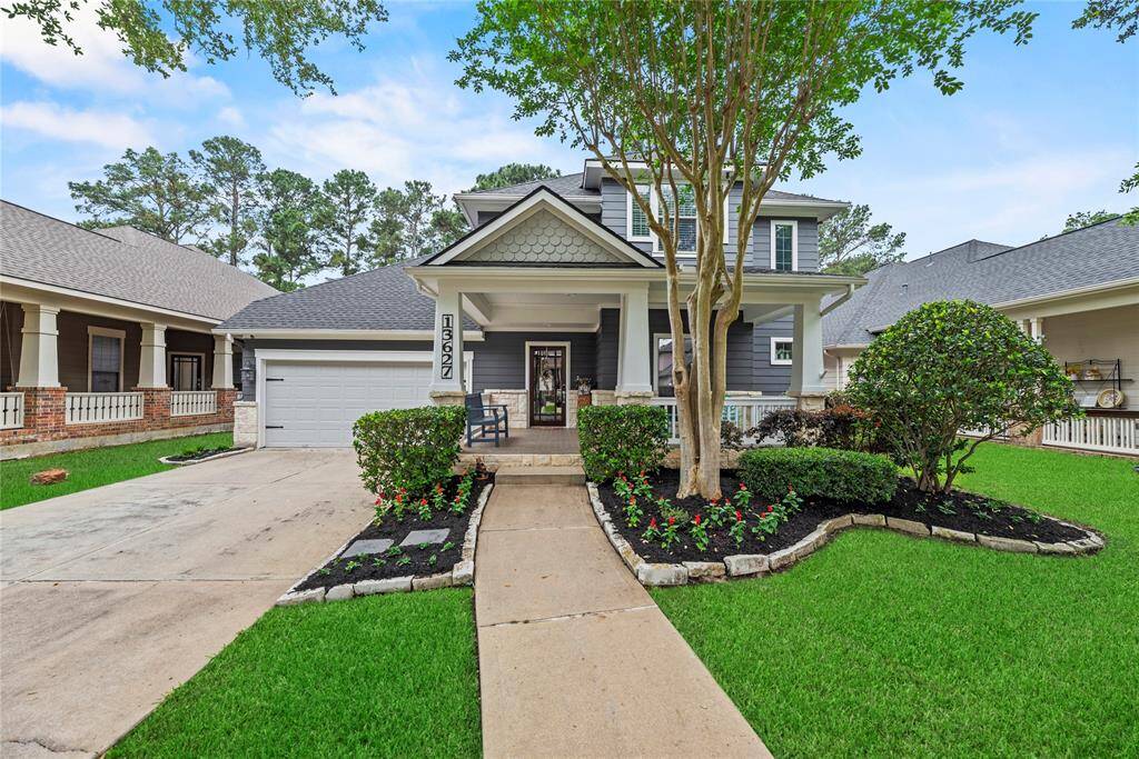 Welcome to 13627 Cardinal Flowers. A charming two-story Craftsman home with a welcoming front porch and well-maintained landscaping and mature trees, creating an inviting curb appeal.