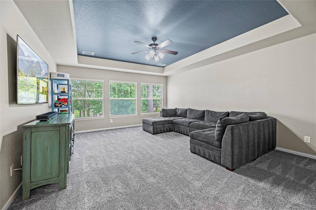 This spacious upstairs multi functional room features large windows with views of greenery and trees behind the home. This is a great play, game or additional living space for all ages.