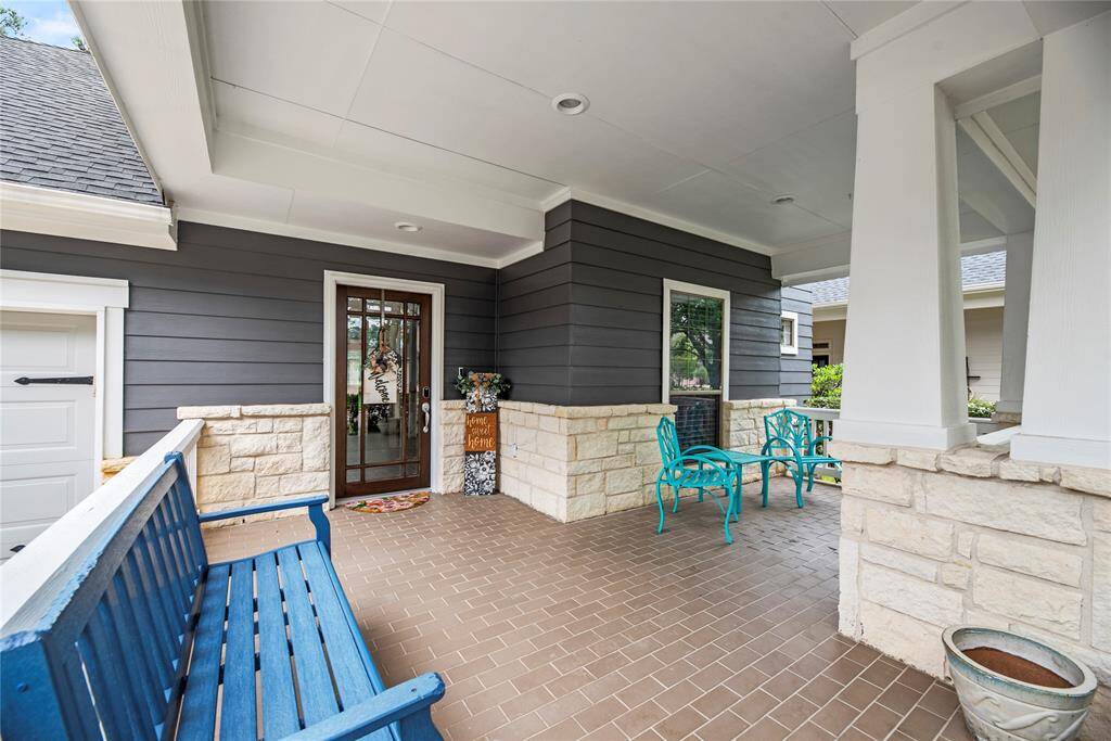 Charming front porch featuring a mix of stone and recently painted siding with an ample sized seating area, perfect for relaxing and enjoying the neighborhood.