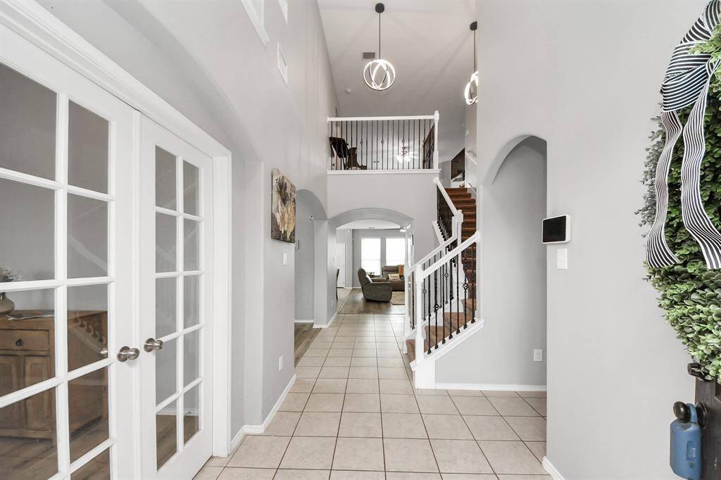 Right when you walk in, you’ll notice the French doors on the left that open up to a private office or study—great for working from home or getting a little quiet time. On the right, the wrought iron stair railing adds a nice touch of character as you head into the rest of the home.