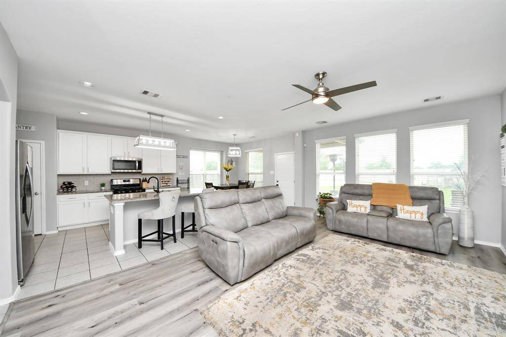 The living room has an open, comfortable feel and flows right into the kitchen—perfect for everyday living or entertaining guests without missing a moment of the action.