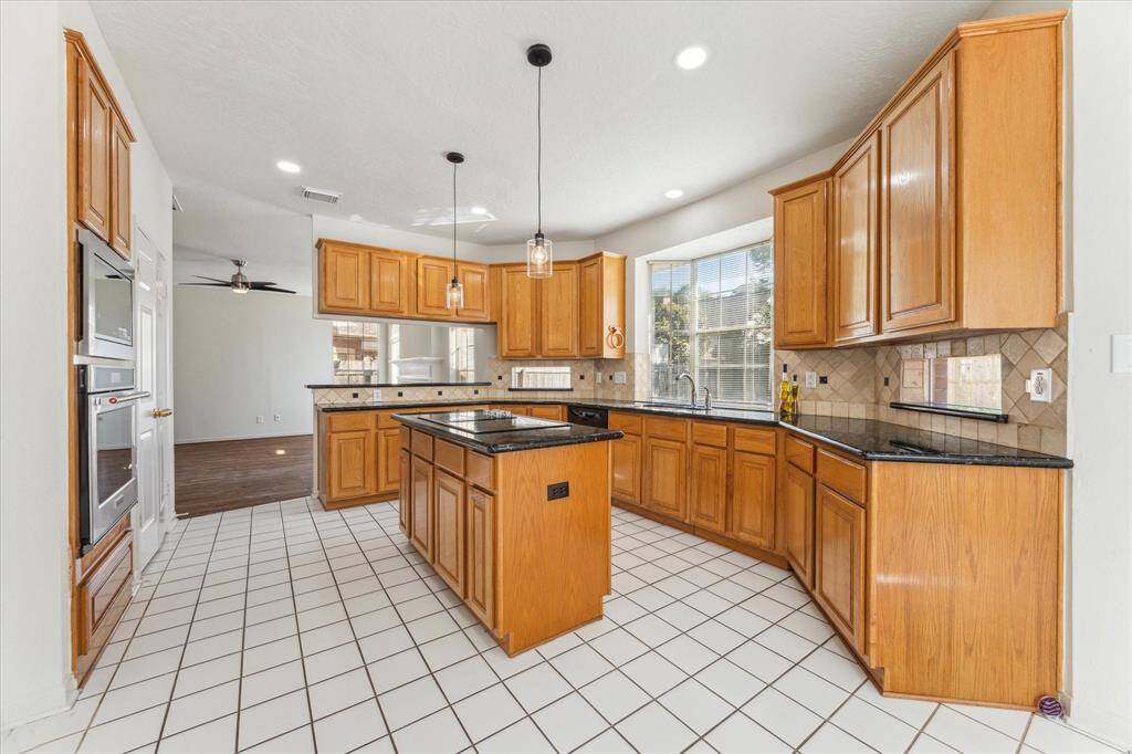 Updated kitchen appliances include the Oven, Microwave and island cooktop.