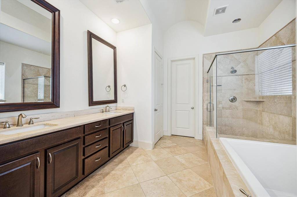PRIMARY BATHROOM.   With double sinks, soaking tub and frameless glass shower.
