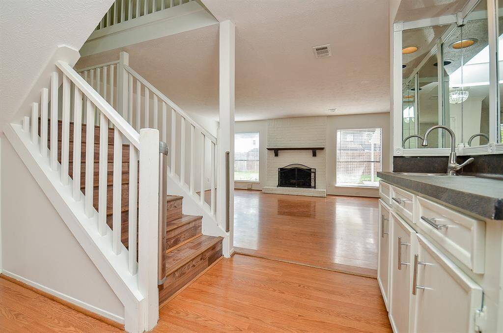 Spacious living room with elegant staircase access.