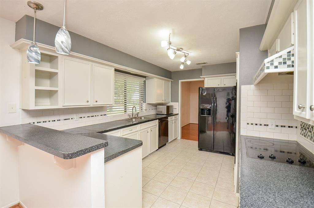 Modern kitchen featuring sleek countertops and ample cabinetry, perfect for culinary creativity.