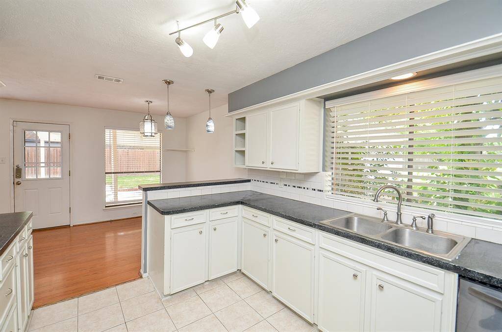 Spacious primary bedroom with elegant wood floors and a serene view and fans throughout the home.