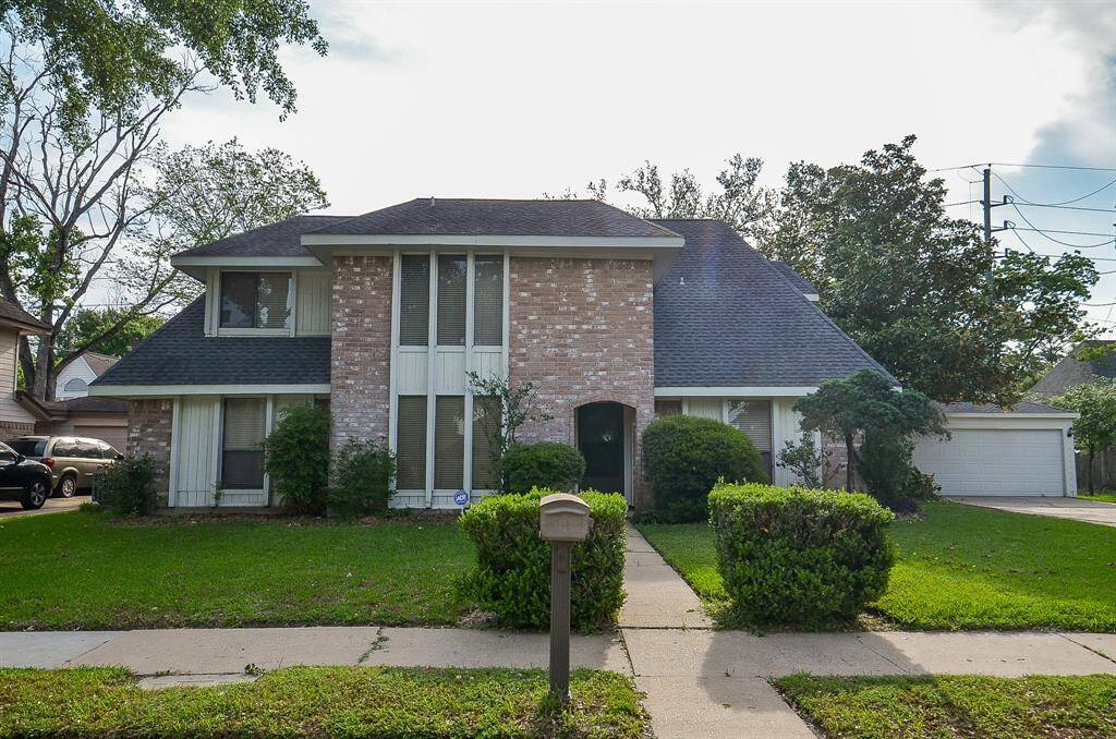 Charming two-story home with a welcoming facade, nestled in a lush, green setting.