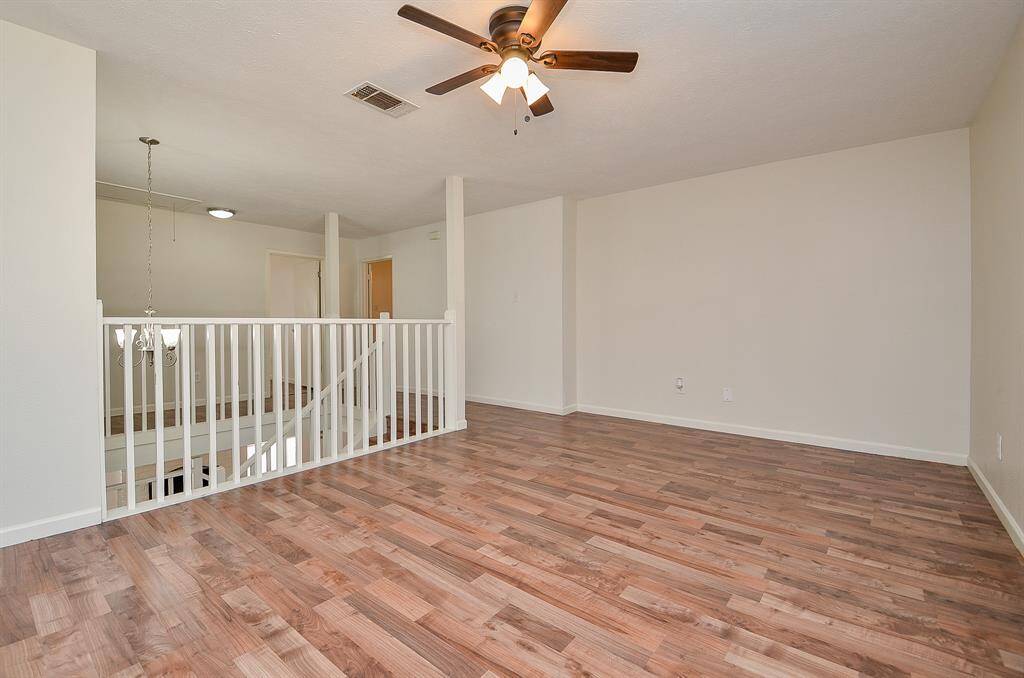 Elegant view from the second-floor landing, showcasing a stylish staircase with beautiful wood flooring.