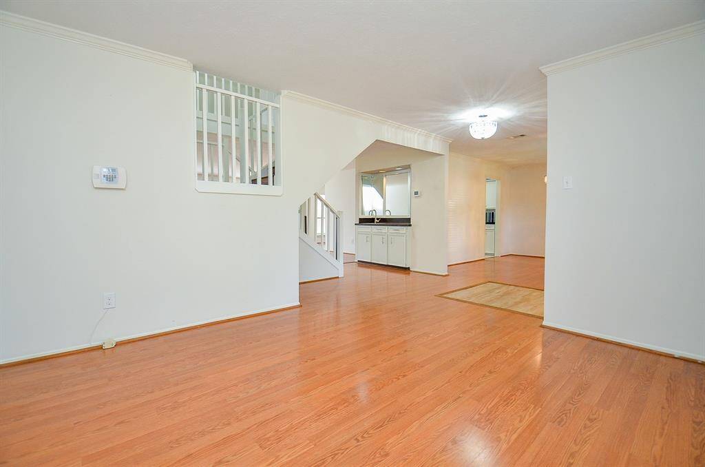 Bright dining room with hardwood floors and a stylish chandelier, perfect for entertaining.