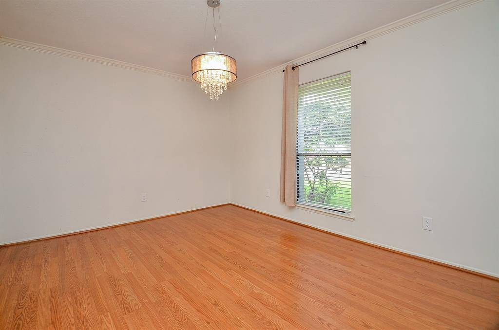 Welcoming foyer opens into a spacious living room, featuring warm hardwood floors and a cozy fireplace.