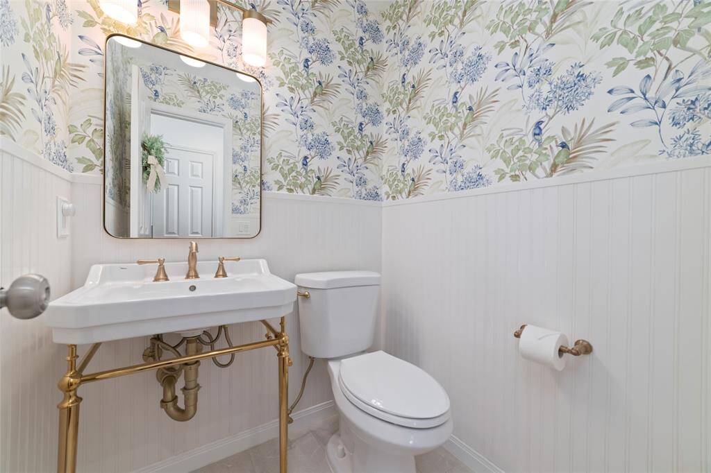 Powder room downstairs totally remodeled with ship lack and beautiful designer style wall paper.