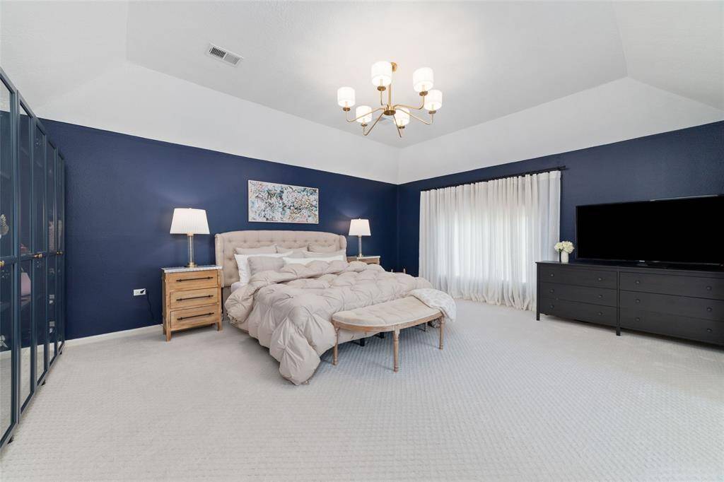 Huge primary bedroom with high ceilings.