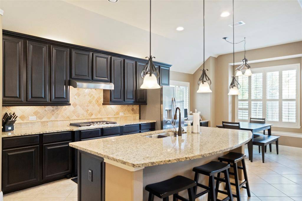 A closer look at the gourmet kitchen’s high-end finishes, from the custom tile backsplash to the elegant granite counters and abundant cabinet storage.