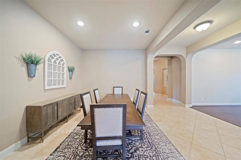 Charming formal dining room highlighted by arched entryways, recessed lighting, and stylish wall accents. A spacious layout easily accommodates large gatherings.
