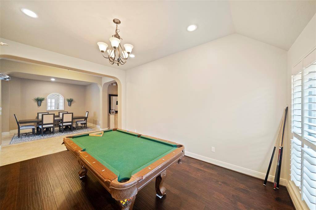 Bright and inviting breakfast nook featuring large windows with plantation shutters, providing serene views of the backyard. The space is enhanced by a classic light fixture and neutral tile flooring, perfect for morning coffee or casual dining.