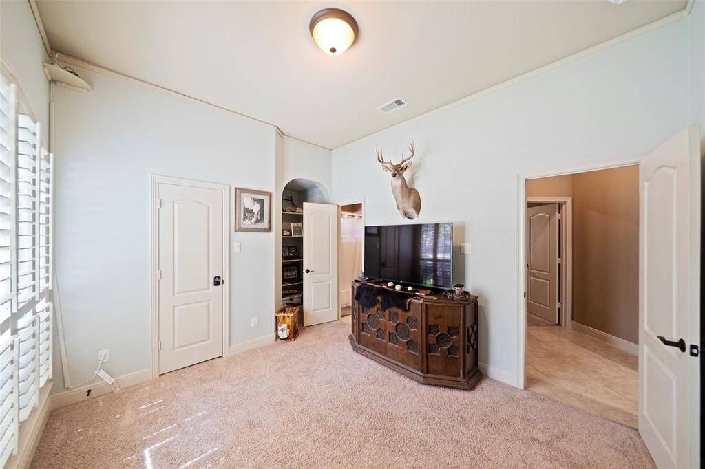 Secondary bedroom with vaulted ceilings, plush carpet, and soft natural light—features a walk-in closet and direct access to the hallway bath.