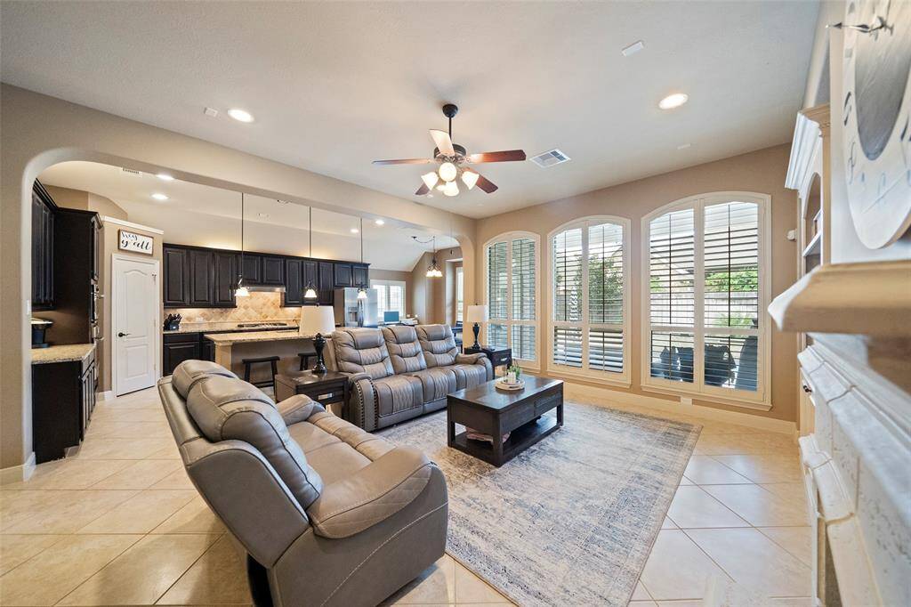 Expansive open-concept living and kitchen area ideal for entertaining. Enjoy seamless flow from the living room into the gourmet kitchen and dining spaces, all bathed in natural light from the wall of arched windows.