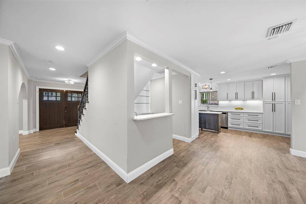 Elegant wet bar with illuminated built-in cabinets and a bar sink.