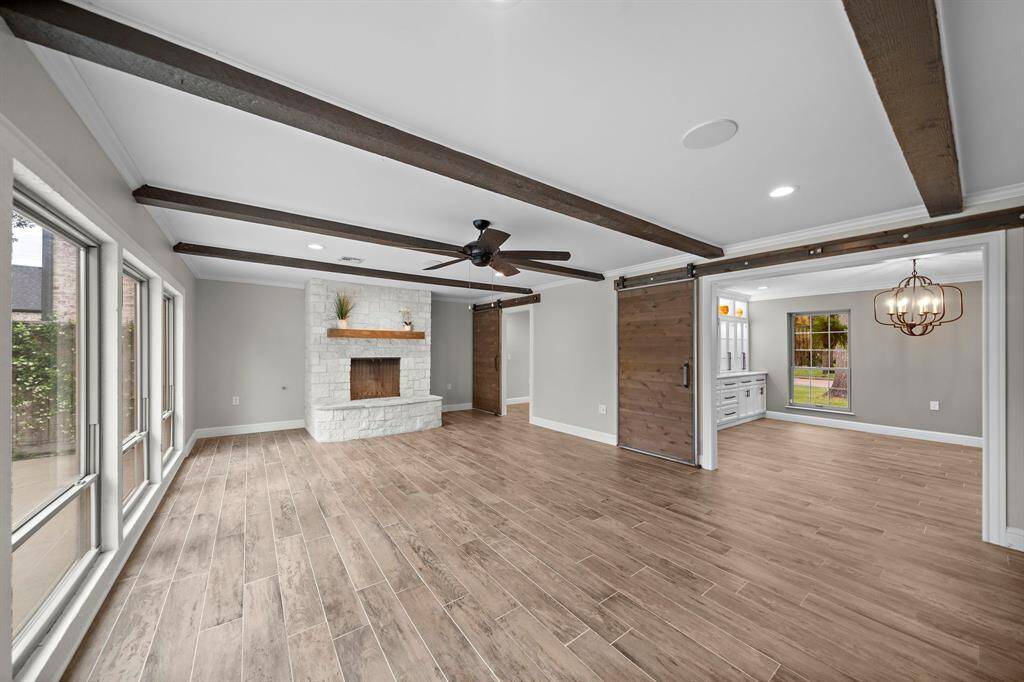 Dramatic beams highlight the family room and stylish barn doors offer privacy to the office and the dining room.