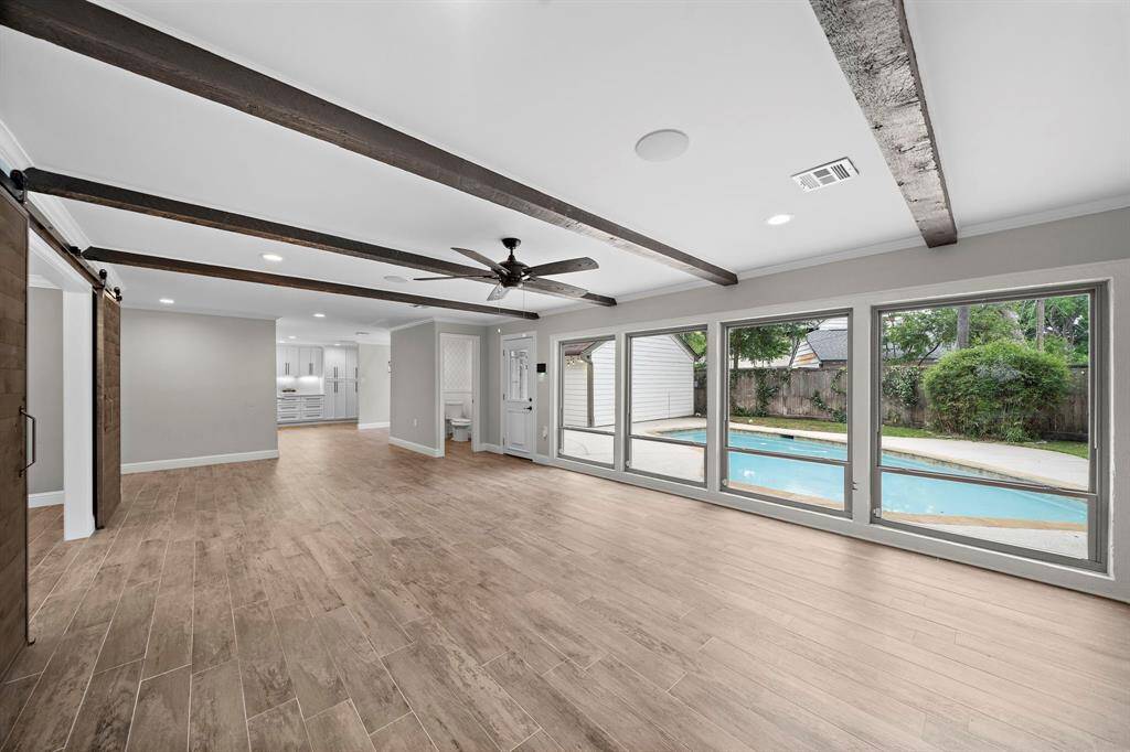 Expansive windows showcase stunning views of the pool and outdoor living area.