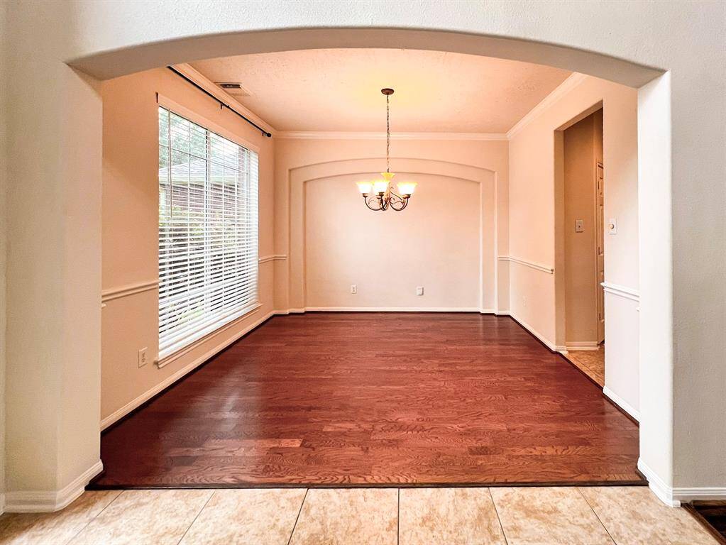 Elegant front formal area with rich wood flooring and abundant natural light.