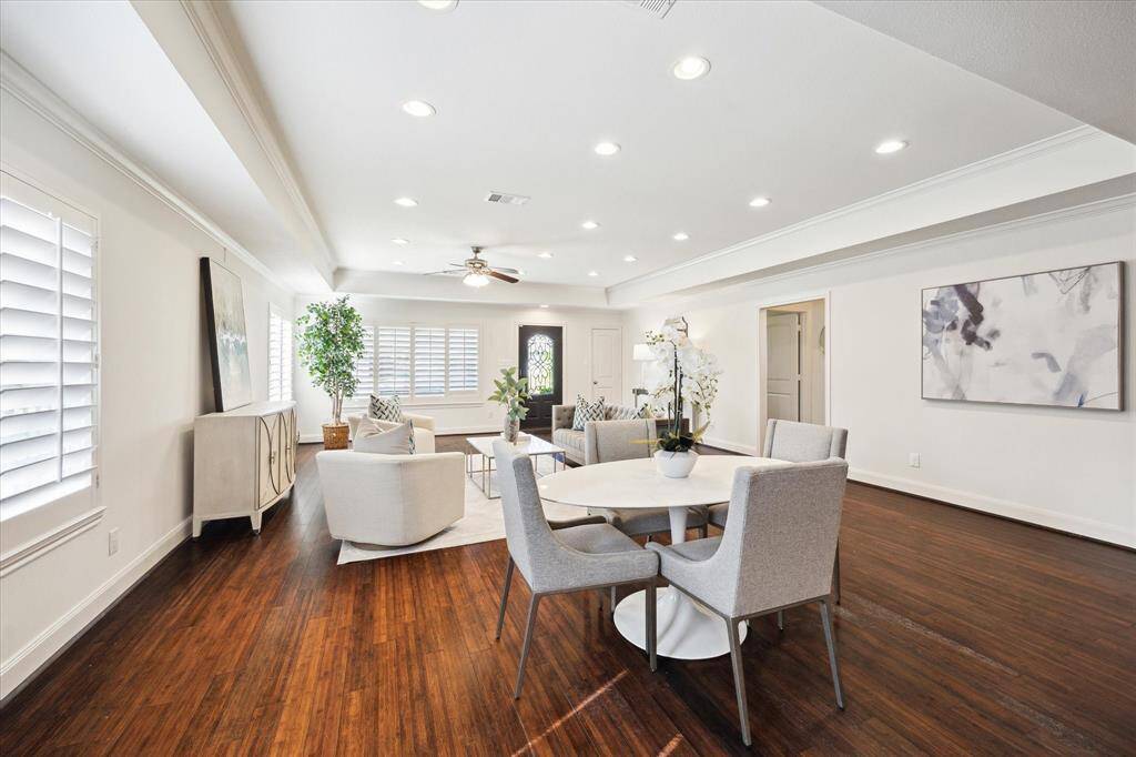 This spacious, modern living area features hardwood floors, recessed lighting, and a neutral color palette.