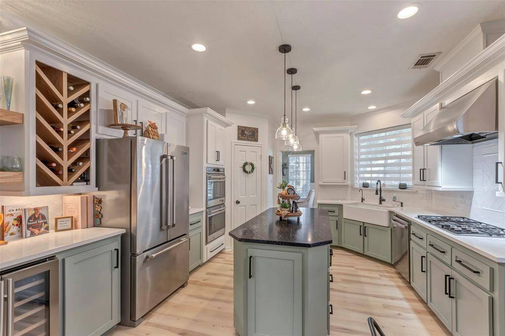 Corner farmhouse sink, impressive backsplash and a built in beverage center.