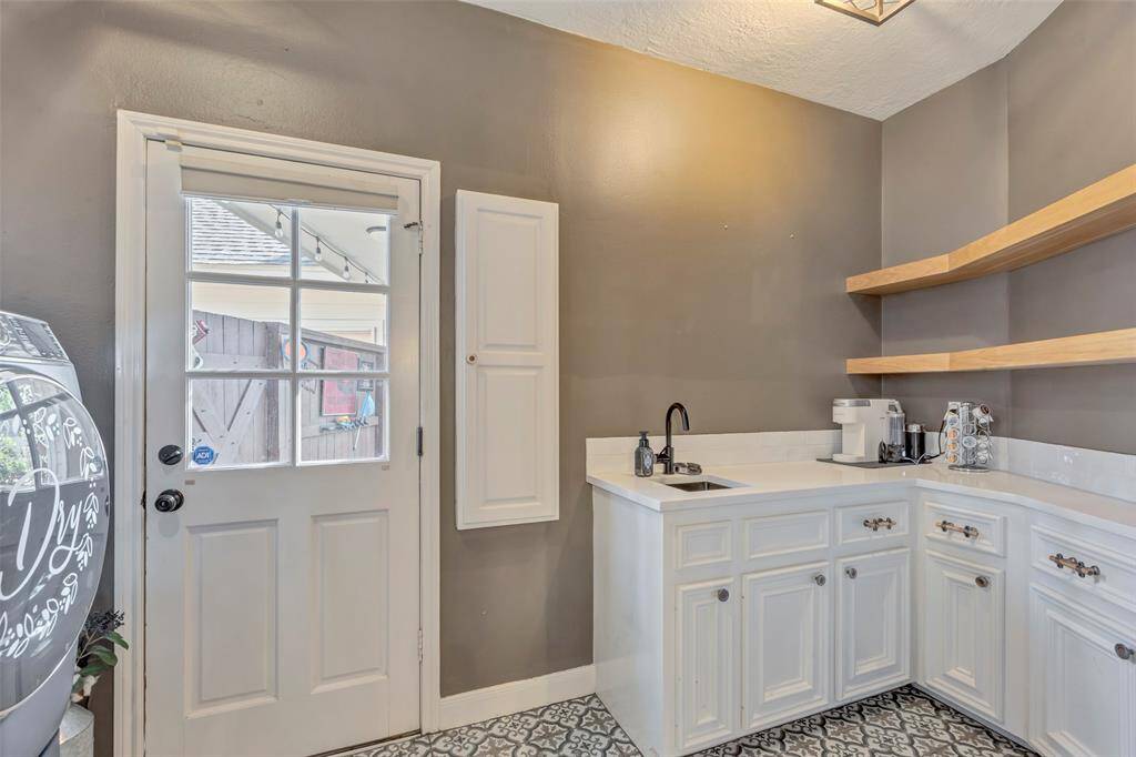 Stylish utility room off the back entry with built-ins.  Great place for a dry bar!