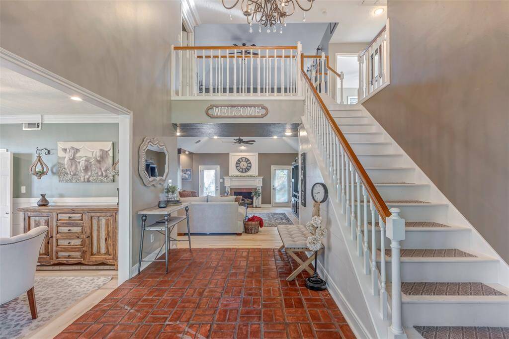 Brick entry with towering stairway open to upstairs gameroom.