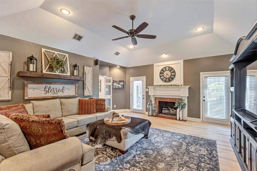 Family room with door to breakfast room- notice the tall ceilings, can lights and beautiful brick fireplace.