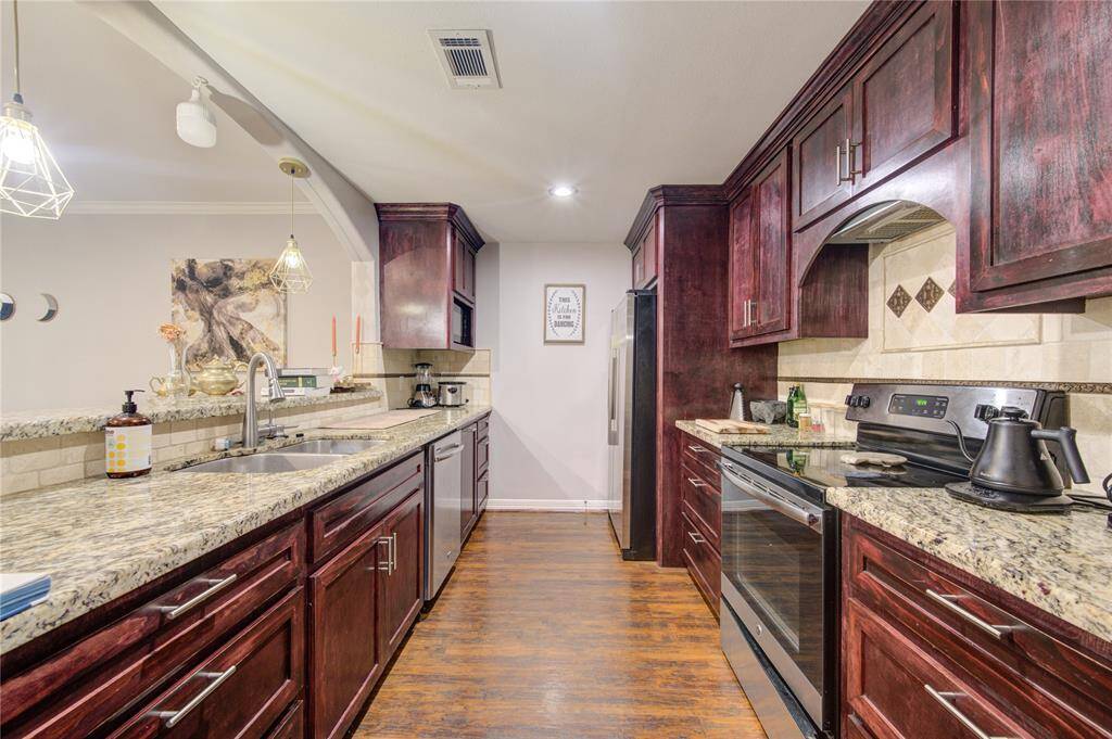 Experience the elegance of this well-appointed kitchen, where rich dark wood cabinetry and sleek granite countertops create a sophisticated look.