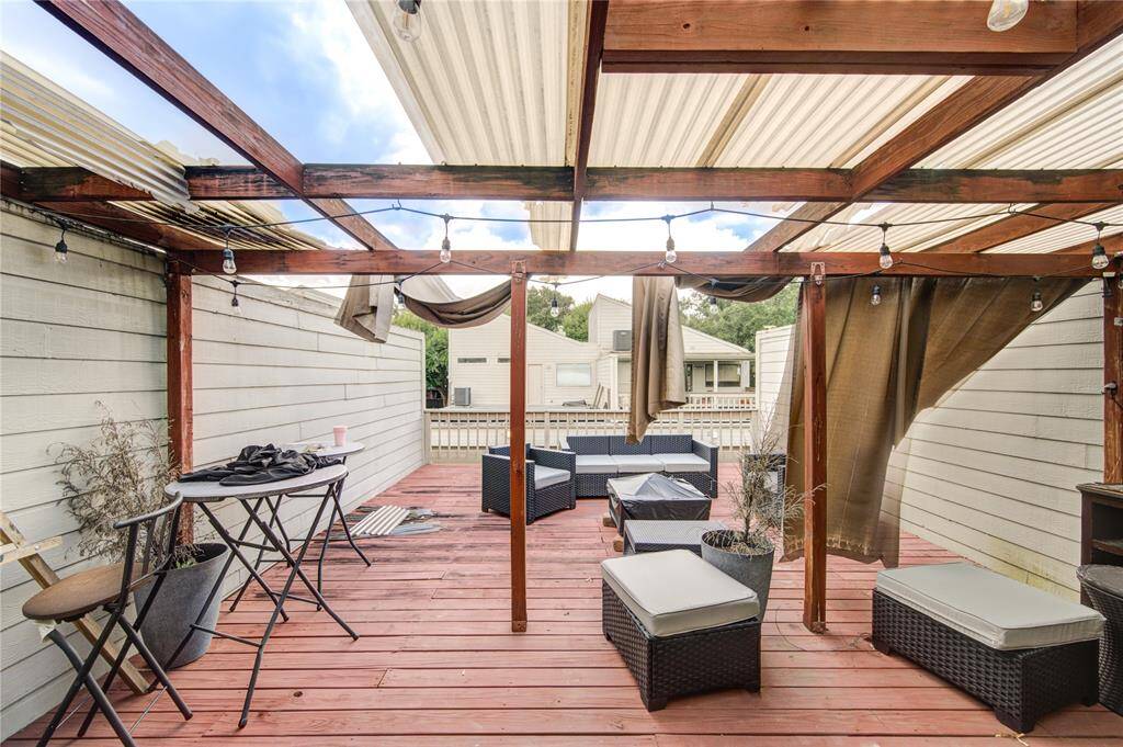 Step into a charming outdoor retreat where a cozy, covered wooden deck awaits, offering the ideal setting for both intimate dinners and laid-back lounging.