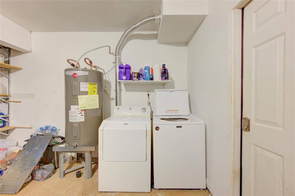 Discover this practical utility room, featuring essential appliances including a water heater, washer, and dryer, along with convenient storage shelves.
