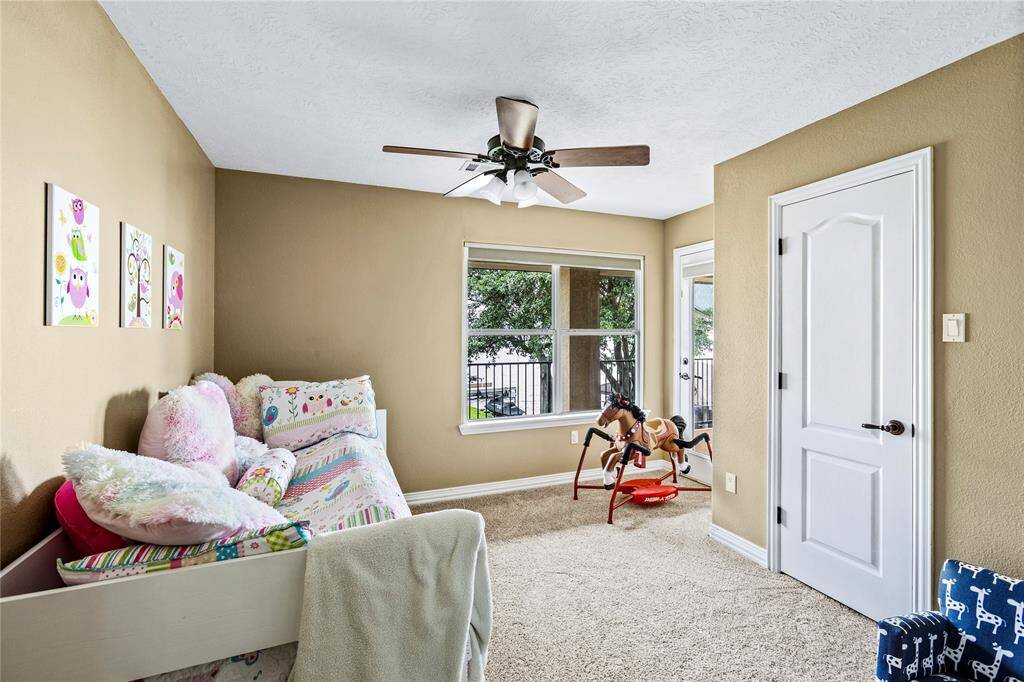 Upstairs secondary bedroom with water views and covered patio access.