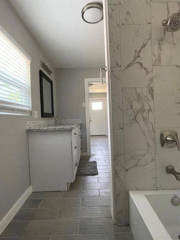 This beautifully renovated bathroom offers tile flooring, a shower/tub combo with gorgeous tile and a designated vanity space.
