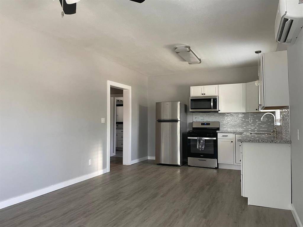 This open-concept space offers wood-tile flooring and convenient split A/C unit for comfort and convenience.