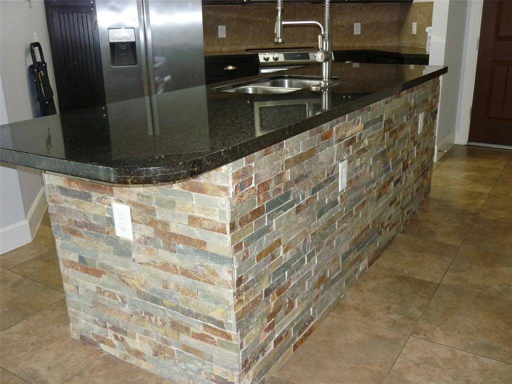 Stone accent wall surrounds island