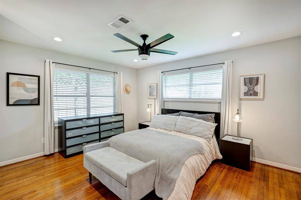 Primary bedroom sits on the back of the home and features 3 closets, hardwood floors, recessed lighting and ceiling fan.