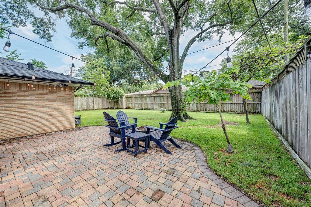 Paver patio area is great for enjoying the fenced backyard. Trees shade the yard.